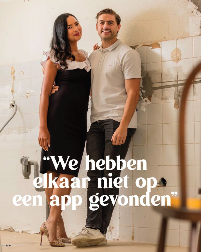 Portret van een jong stel staand in een huis dat verbouwd wordt, tegen een achtergrond van kale tegels en leidingen. Redactionele fotografie voor dorpsglossy BAMI over samenwonen en klussen in Berlicum.